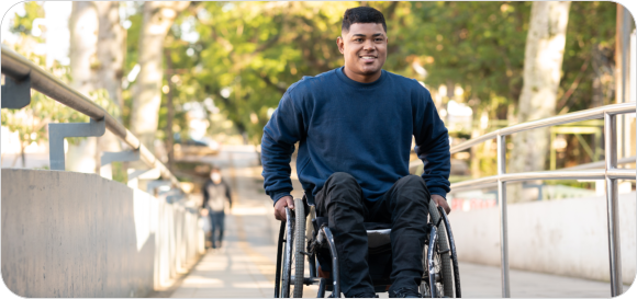 person in wheelchair finishing to climb access ramp.