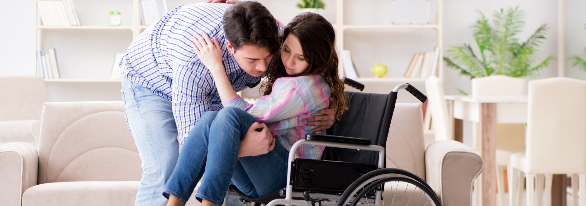 man is lift the woman from the wheelchair