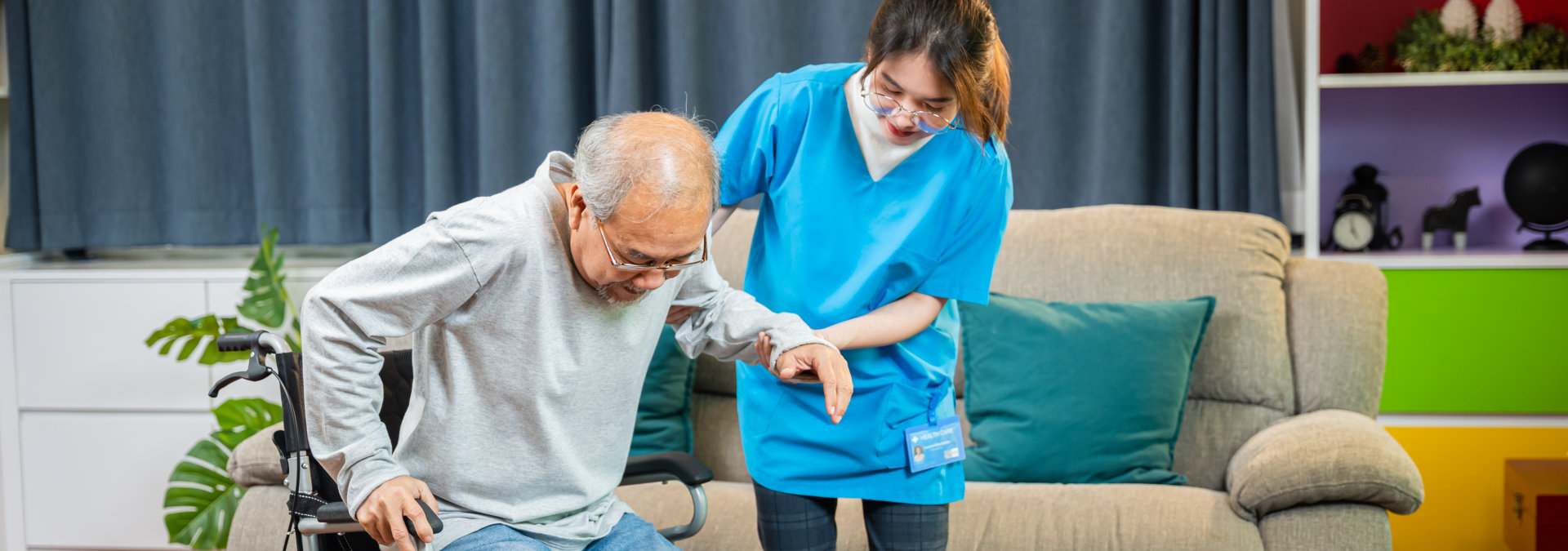 caregiver is helping the senior man to stand up