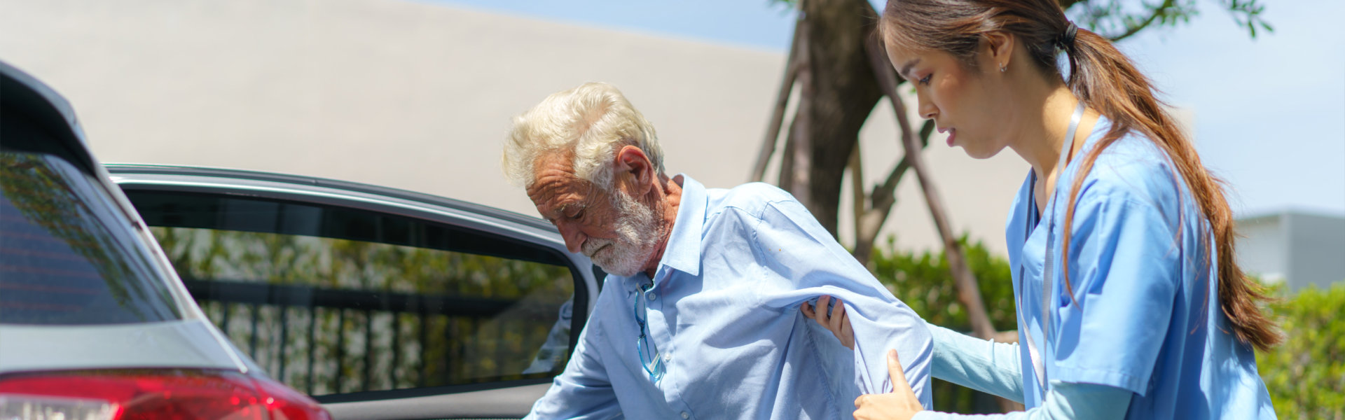 nurse is helping the senior man to get in the car