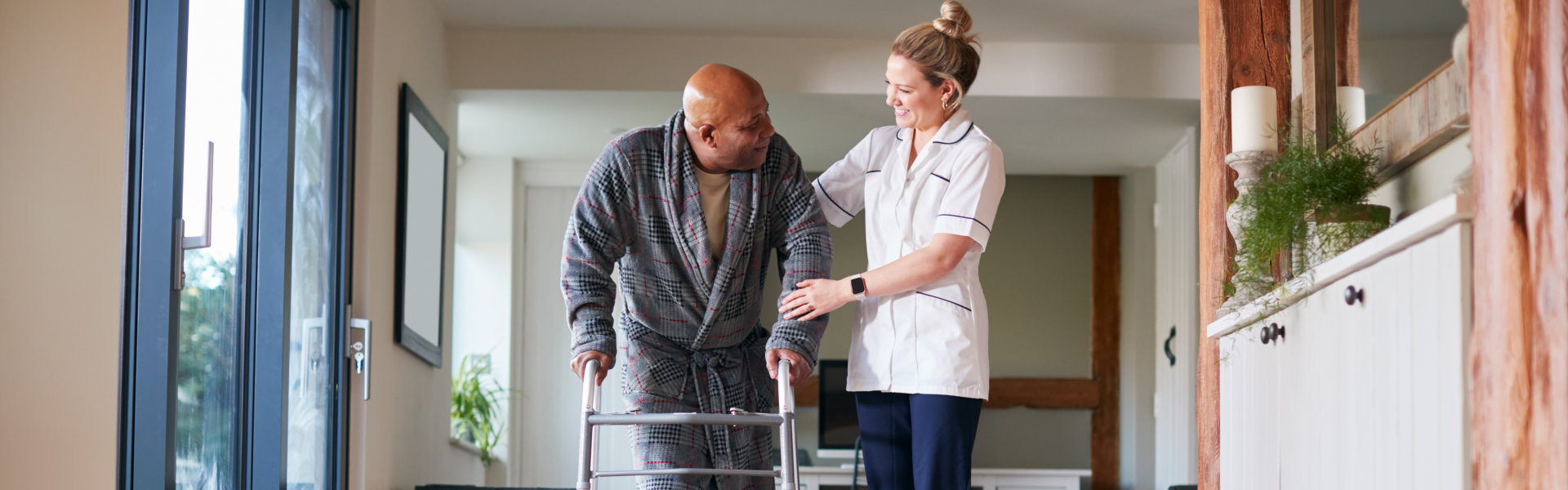 woman is helping senior man to walk