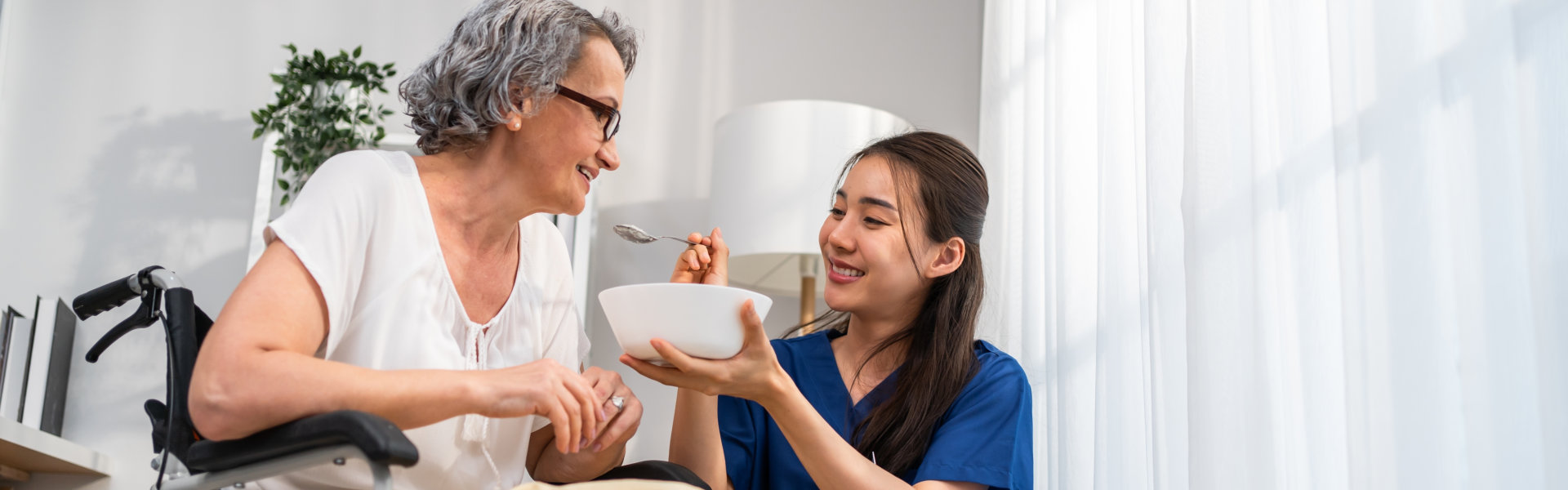 nurse serve food to senior woman at home.