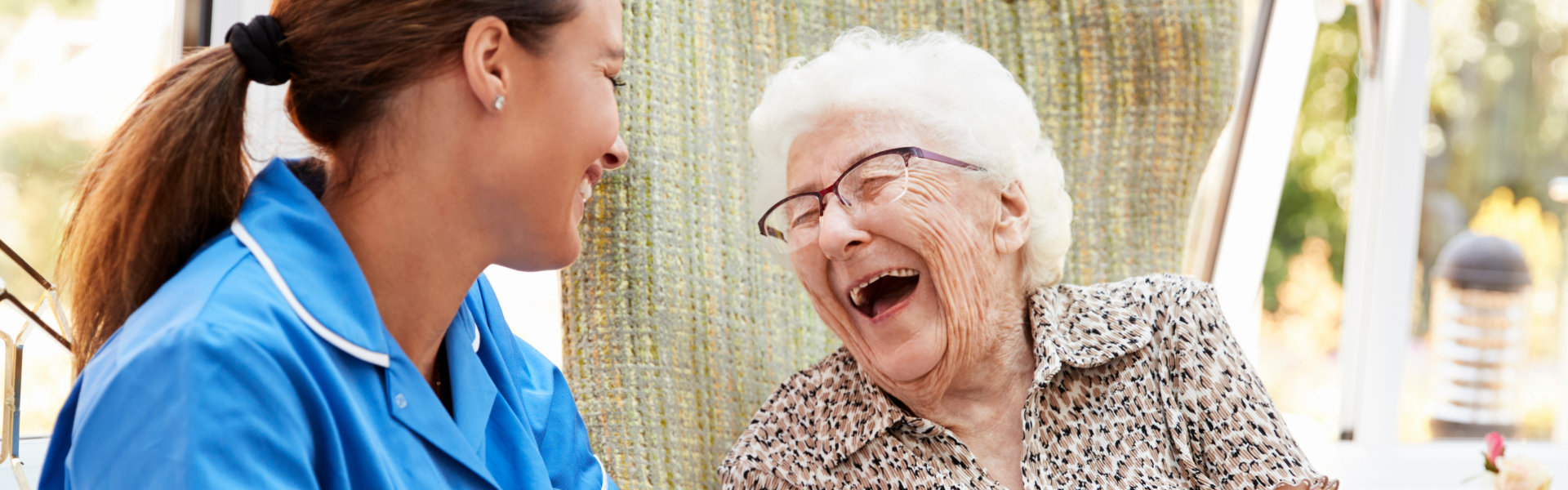 caregiver and senior woman are having fun with their conversation